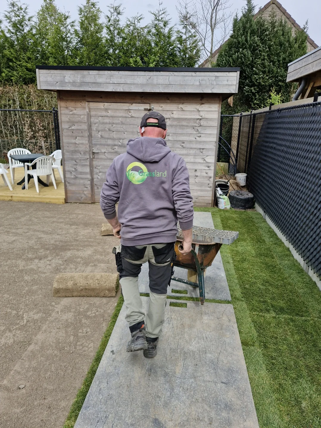Aanleg van graszoden, met Grassland-werkkledij in beeld